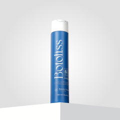 "Botoliss Biotin Shampoo" with a white cap is elegantly placed on a white surface, set against a light gray backdrop.