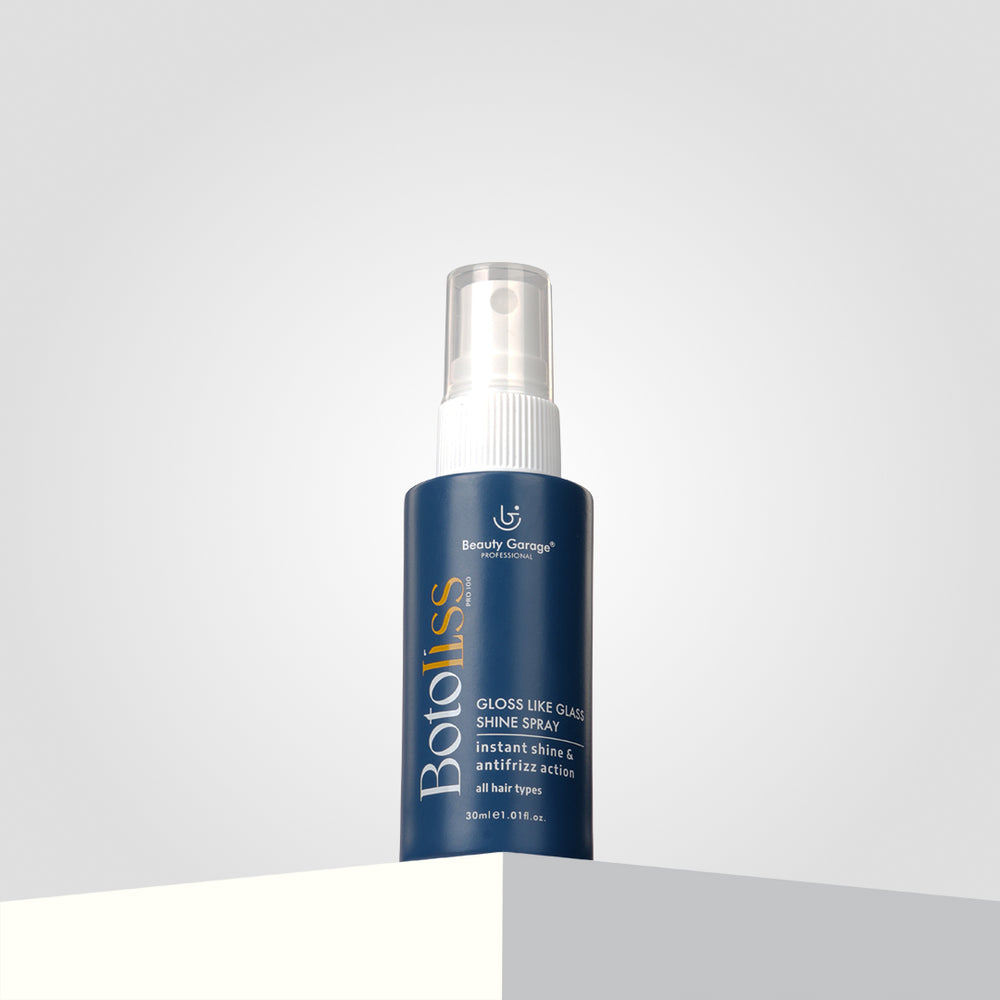 Dark bottle of Botoliss Gloss Like Shine Spray, 30 ml, with a clear cap, sits elegantly on a white, elevated surface.