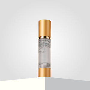 Botoplexx K9 frizz dismiss oil, with a gold cap and clear body, stands upright on a gray surface.