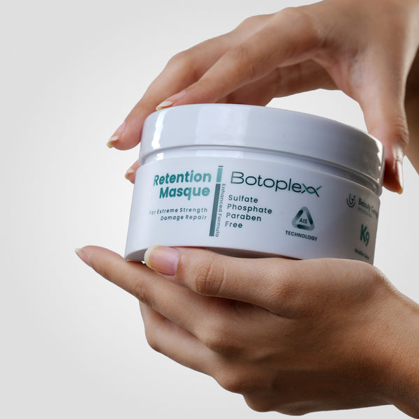 Hands holding a white container labeled "Botoplexx Retention Masque," celebrated for being sulfate, phosphate, and paraben free.