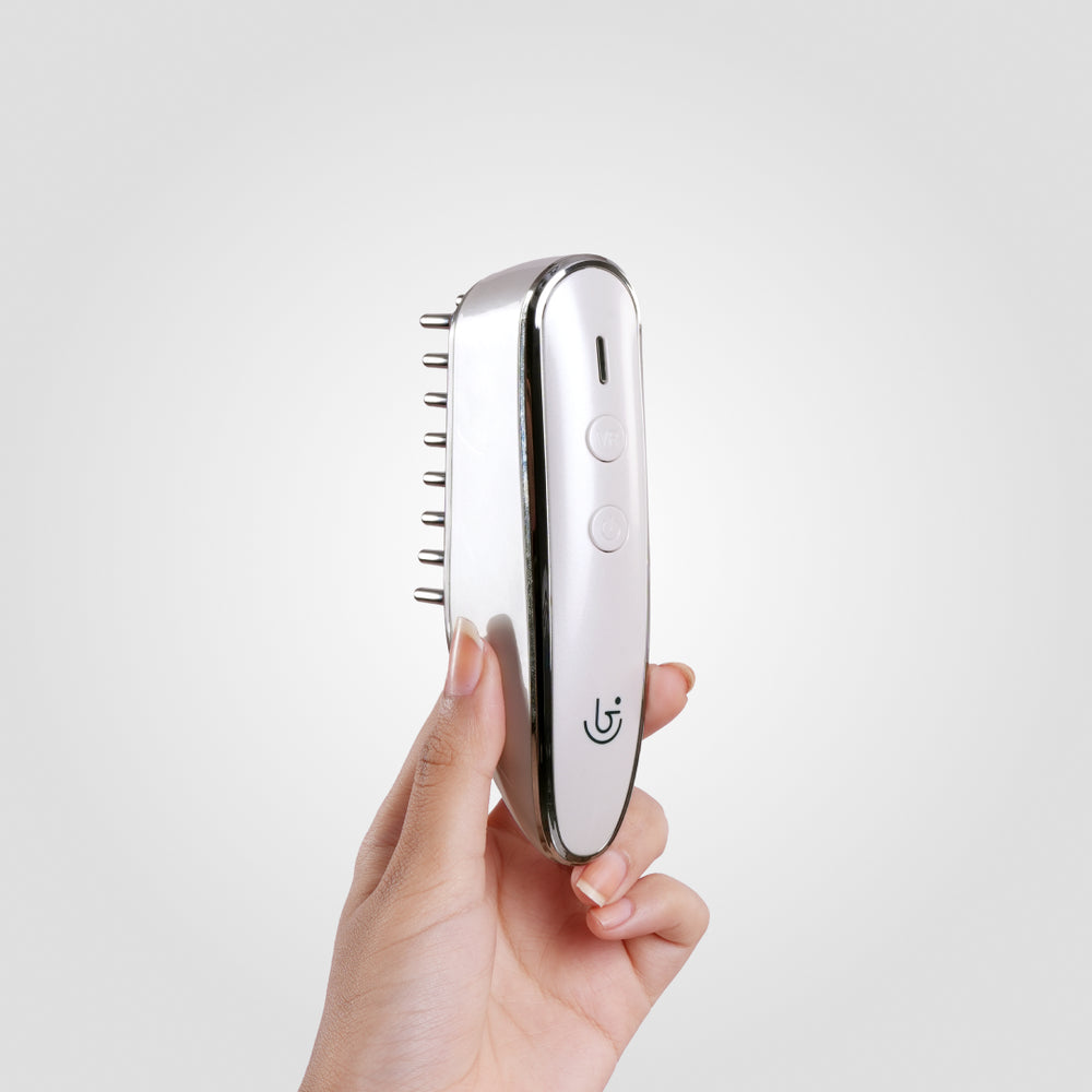 Electric hair growth comb features two buttons, marked "VR" and "power," inviting curiosity with its minimalistic design.