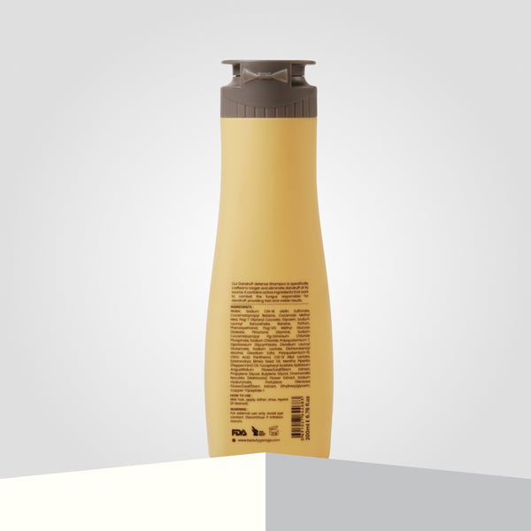 A yellow plastic bottle of ScalpSense Dandruff Defense Shampoo with a gray flip-top cap and text on the back.