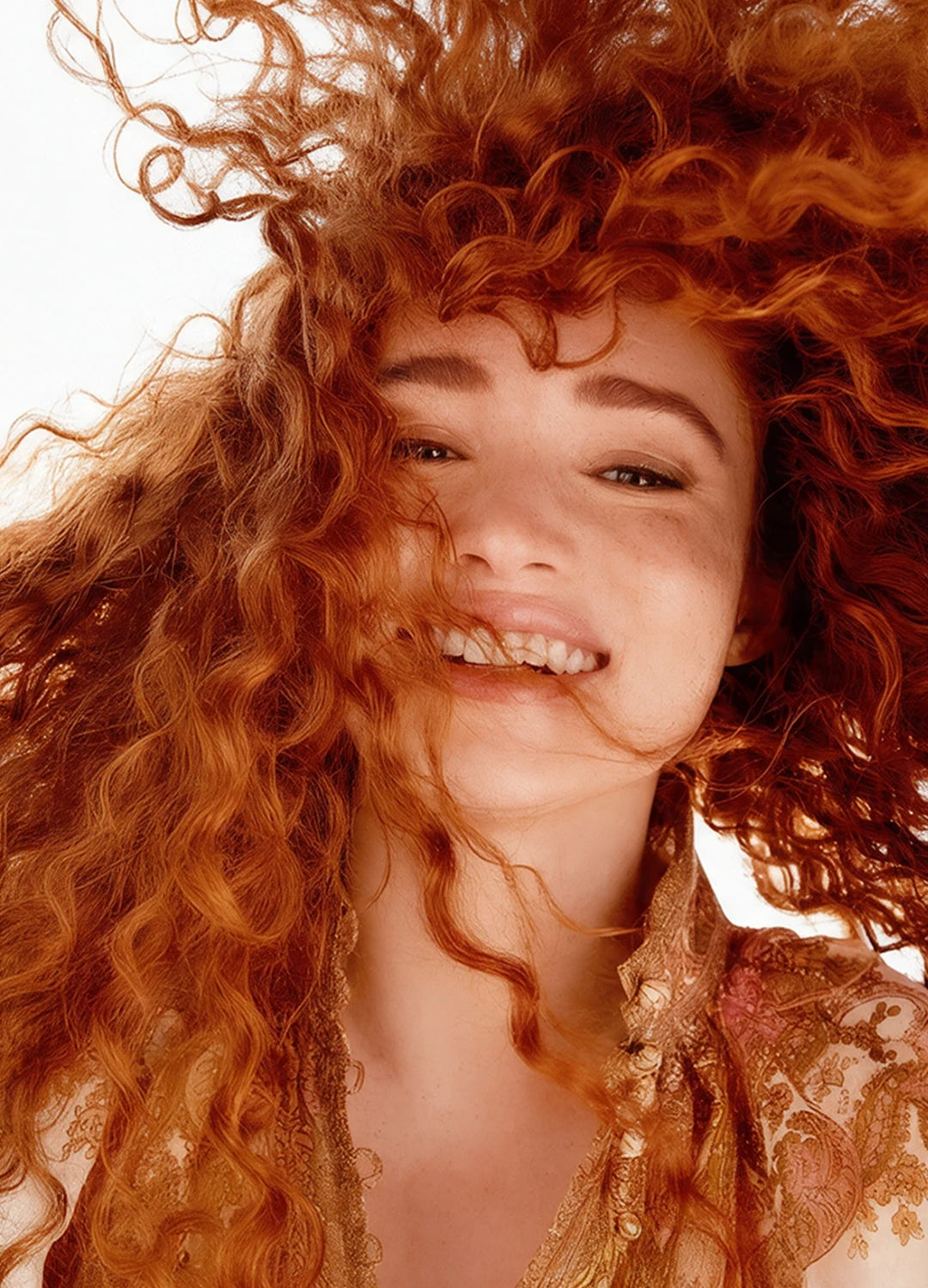 Woman with voluminous red curls in motion