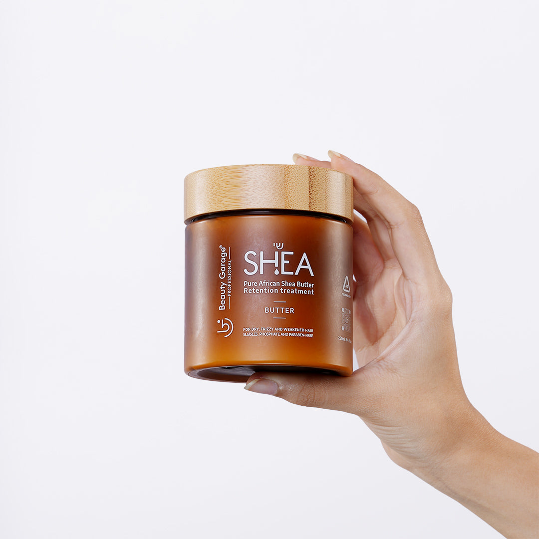 A hand holds a jar labeled "Shea Butter Retention Treatment." with its effective Shea Retention Hair Mask formula.