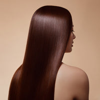 A person with smooth, straight, long brown hair shown from the back against a beige background.